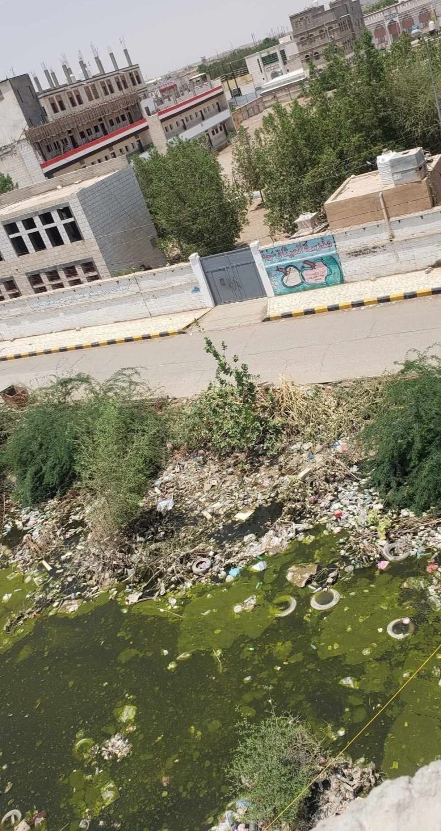 مأرب.. مستنقع مائي أمام مدرسة الميثاق يهدد صحة الطلاب والأهالي(صورة)